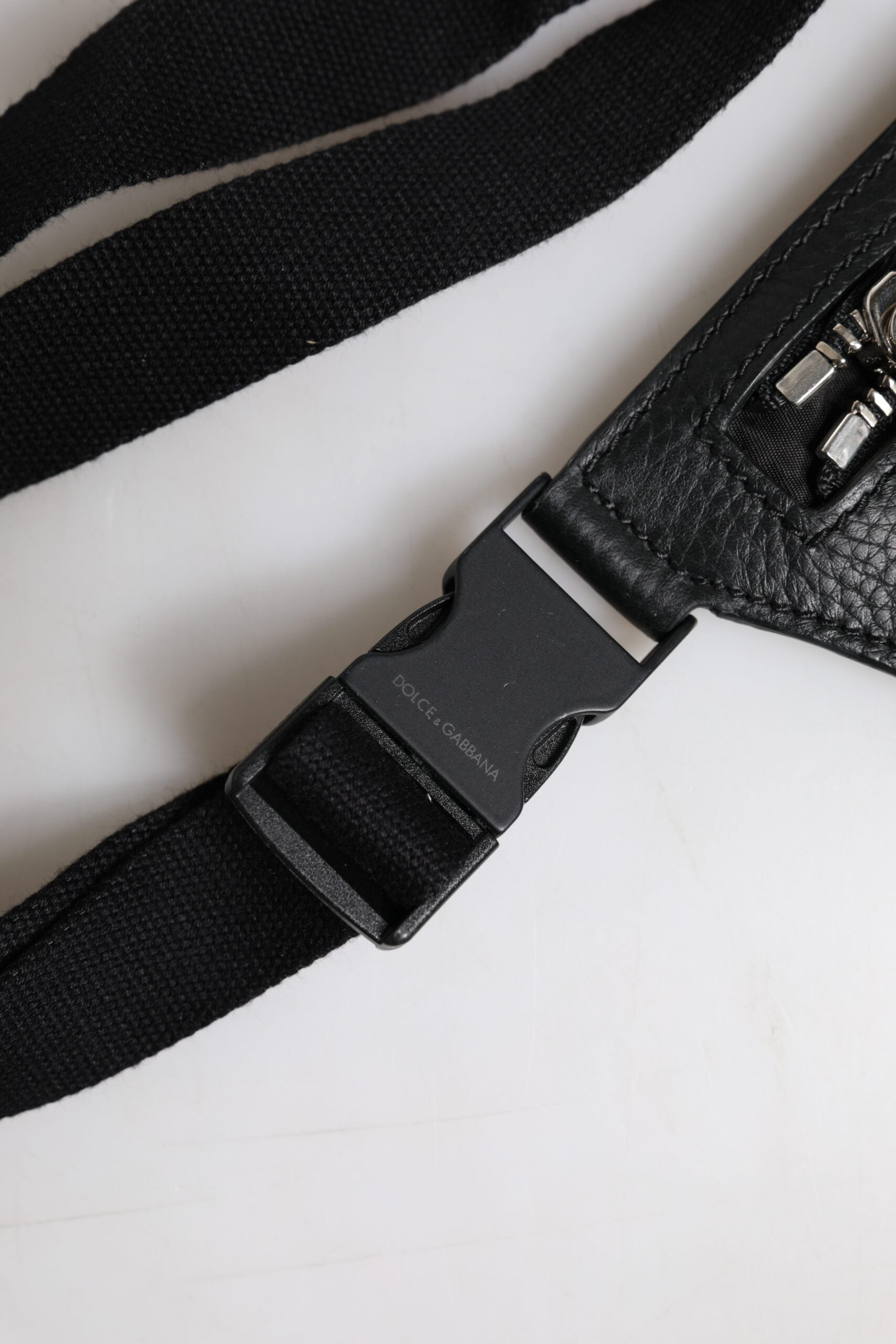 Ceinture en cuir de veau noir Dolce & Gabbana avec plaque logo, portée comme ceinture ou sac banane pour hommes.