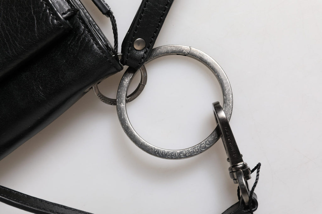 Sac à main Dolce & Gabbana en cuir noir avec logo, porté en bandoulière, élégance et style sophistiqué visible sur l'image.