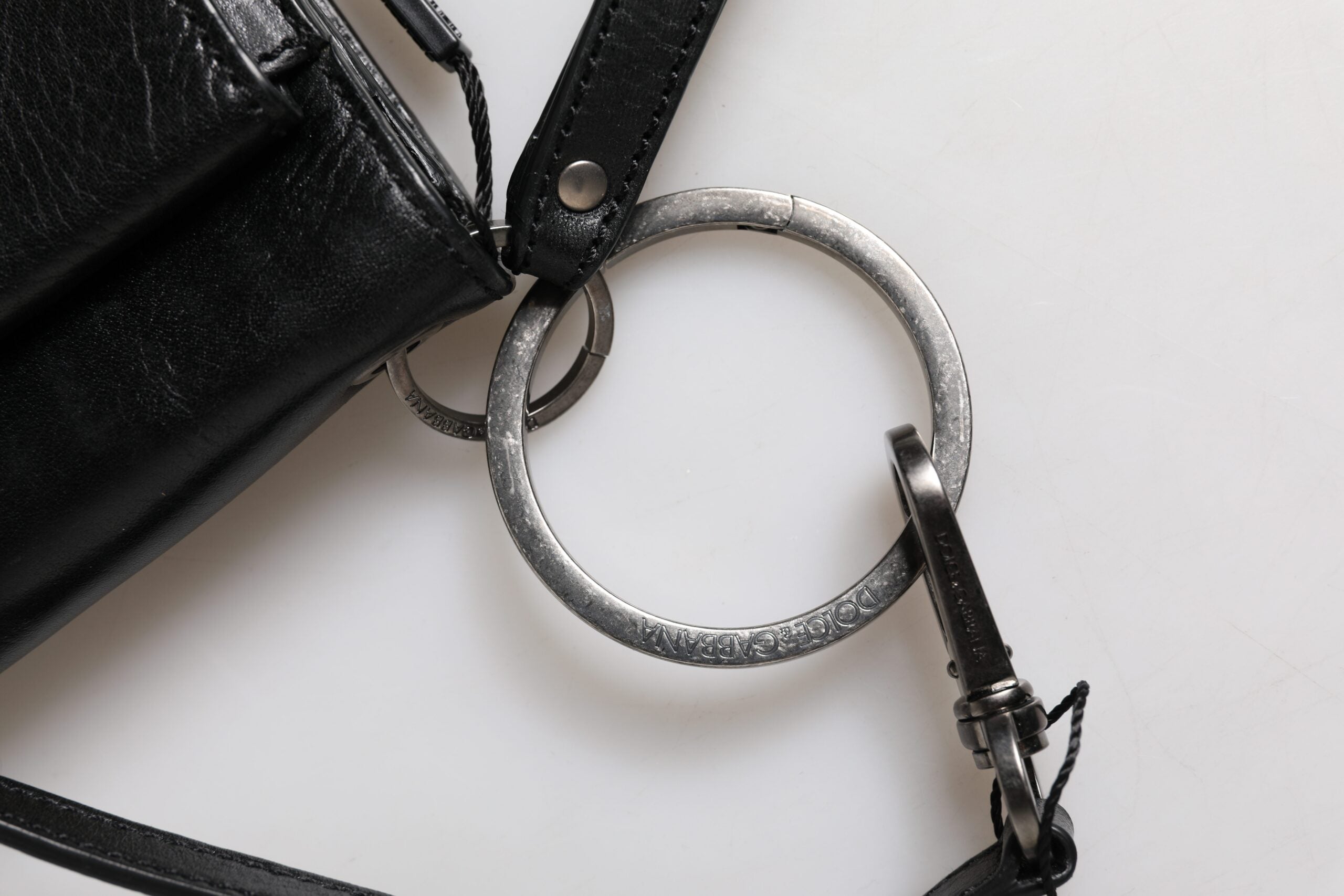 Sac à main Dolce & Gabbana en cuir noir avec logo, porté en bandoulière, élégance et style sophistiqué visible sur l'image.