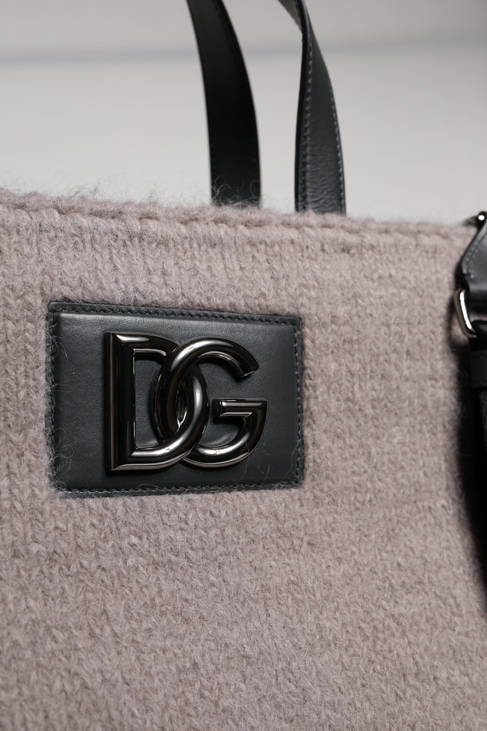Sac cabas Dolce & Gabbana en laine d'alpaga grise avec logo en plaque, porté sur l'épaule, détail élégant et sophistiqué.