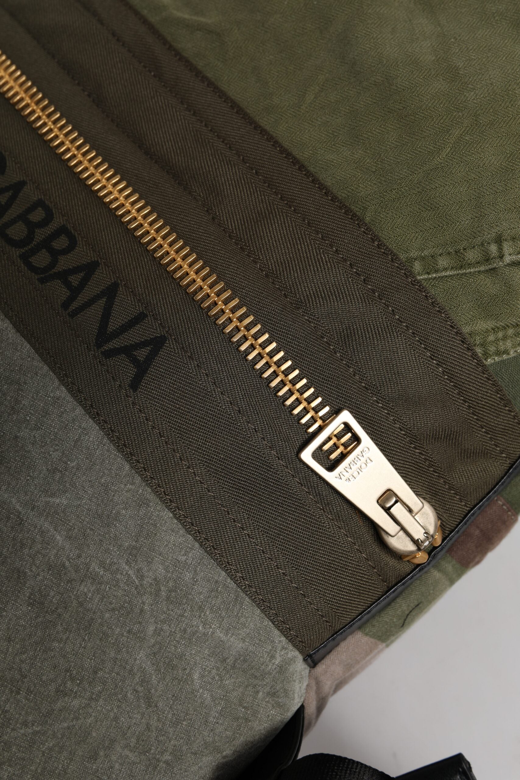 Sac à dos Dolce & Gabbana en patchwork vert militaire, design robuste et tendance, avec plusieurs poches et détails stylés.