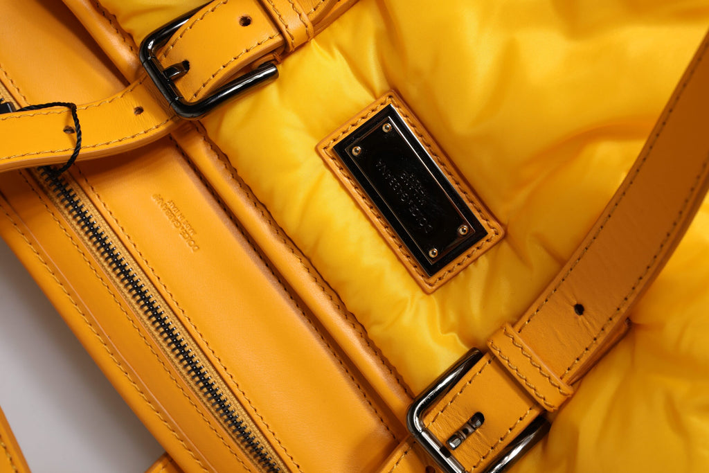 Sac à main Duffle Dolce & Gabbana en nylon jaune et orange avec logo et plaque, porté en main ou sur l'épaule.