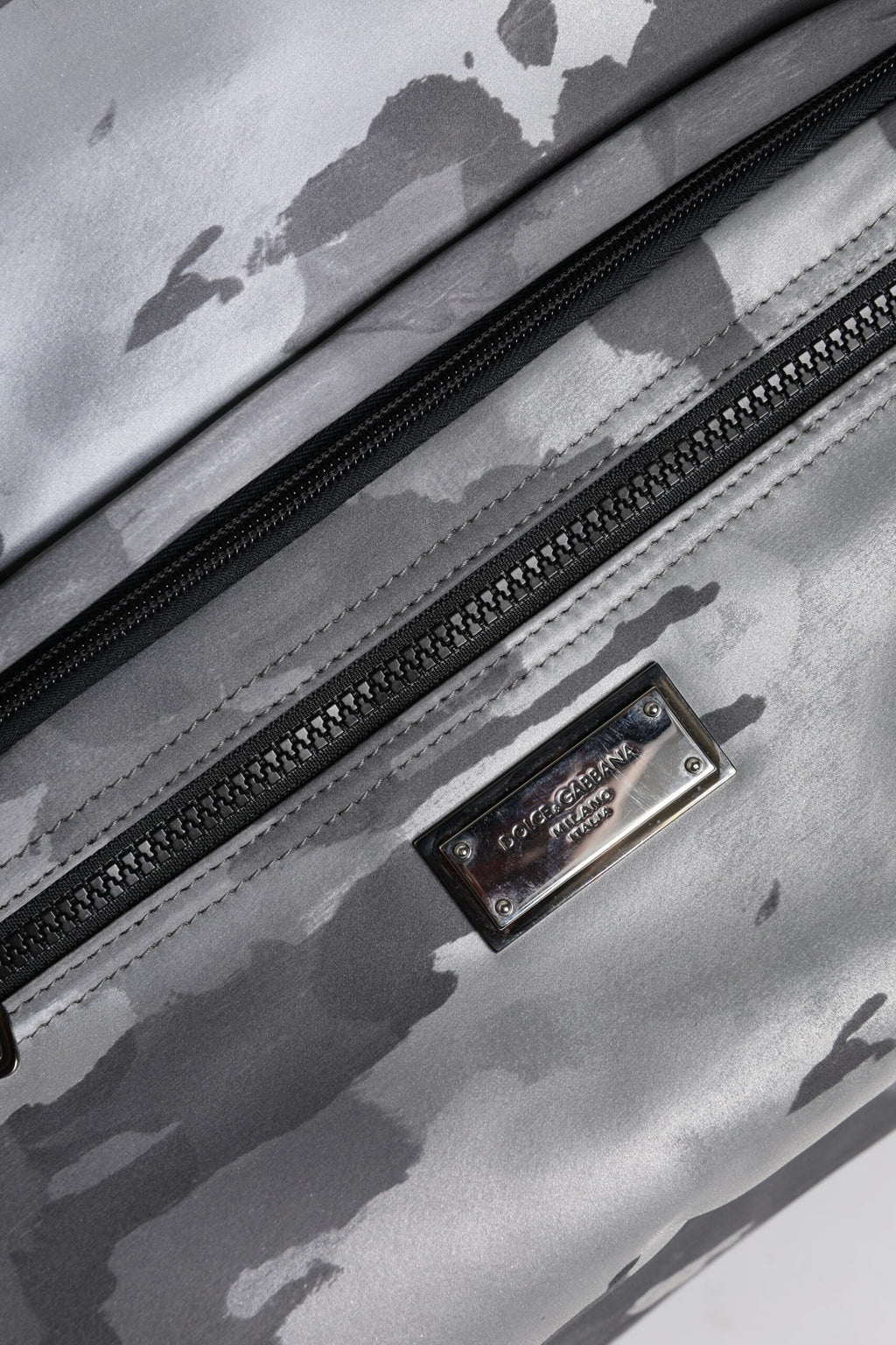 Sac Dolce & Gabbana noir avec bandoulière camouflage, plaque logo et détails élégants, vue de face.