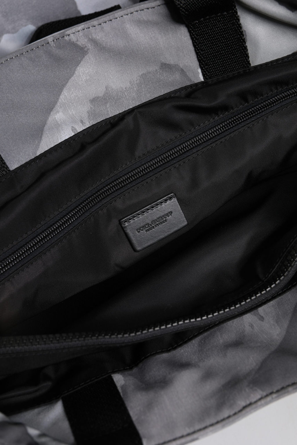 Sac Dolce & Gabbana noir avec bandoulière camouflage, plaque logo et design élégant visible sur l'image.