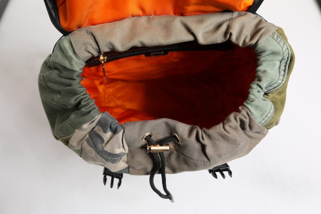 Sac à dos Dolce & Gabbana vert militaire avec patchwork, style scolaire et design tendance visible dans l'image.