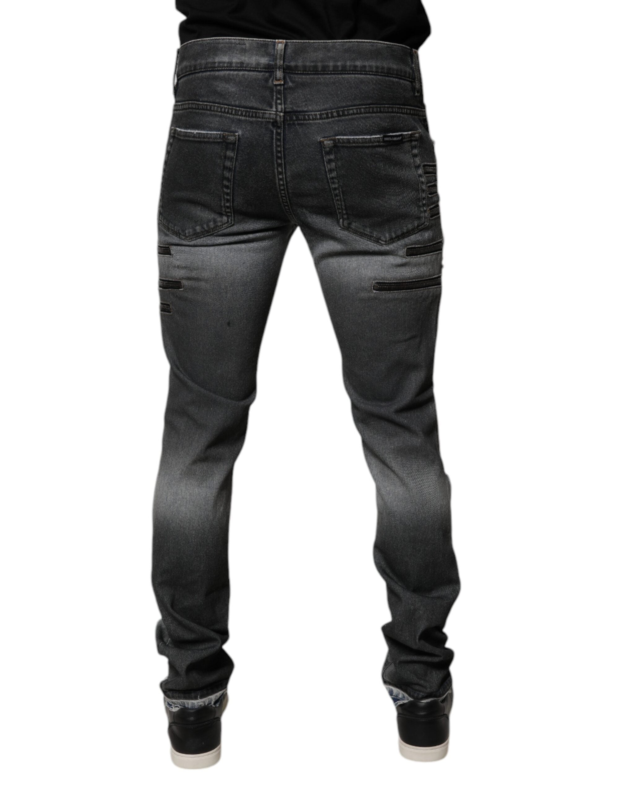 Jeans skinny en denim gris foncé tachetés de coton, de style déchiré, par Dolce & Gabbana, visibles sur l'image.