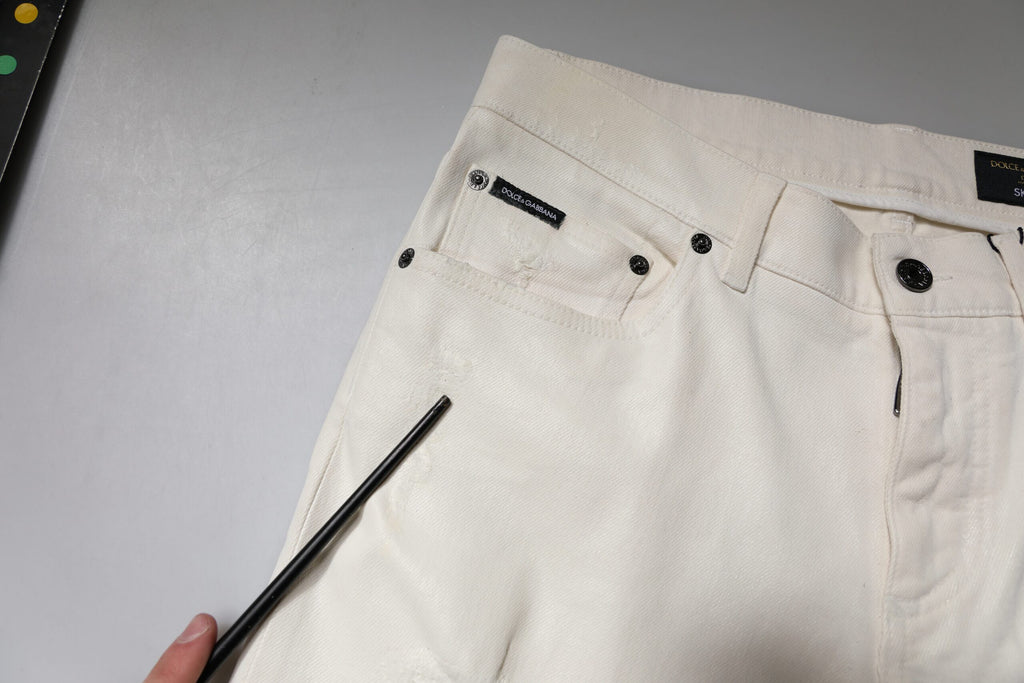 Jeans skinny en coton stretch blanc cassé de Dolce & Gabbana, denim slim ajusté, visible sur le produit.