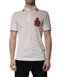 Polo blanc Dolce & Gabbana en coton avec logo, col classique, porté par un homme, style élégant et décontracté.