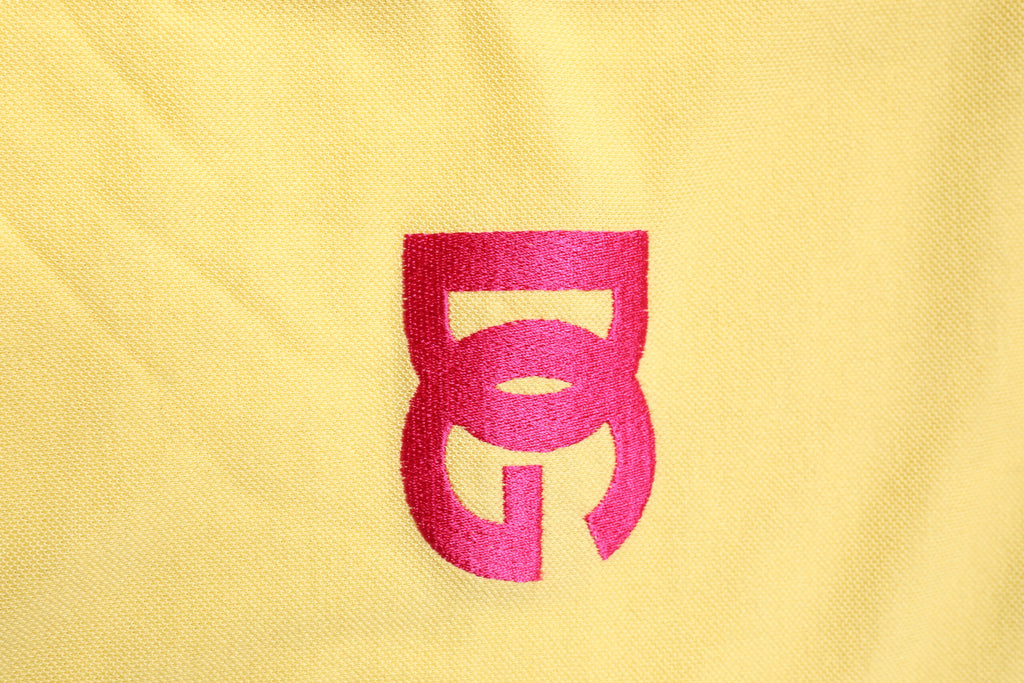 Polo en coton jaune Dolce & Gabbana avec col et logo, vue de face, style élégant et décontracté