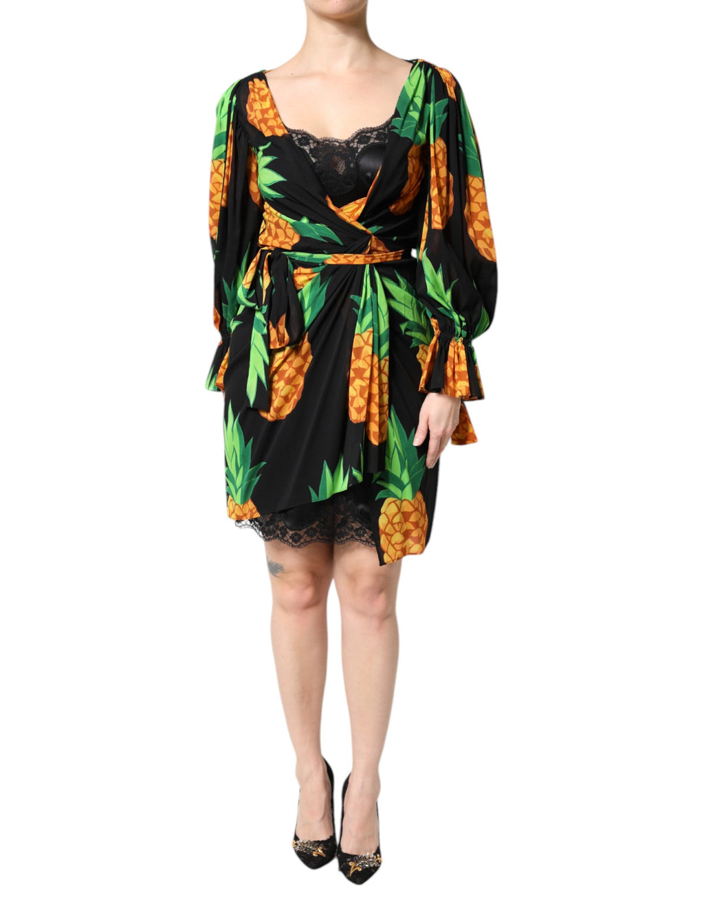 Robe portefeuille en soie noire Dolce & Gabbana avec motif ananas drapé, élégante et fluide, portée avec des détails visibles.