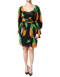 Robe portefeuille en soie noire Dolce & Gabbana avec motif ananas drapé, élégante et fluide, portée avec des détails visibles.