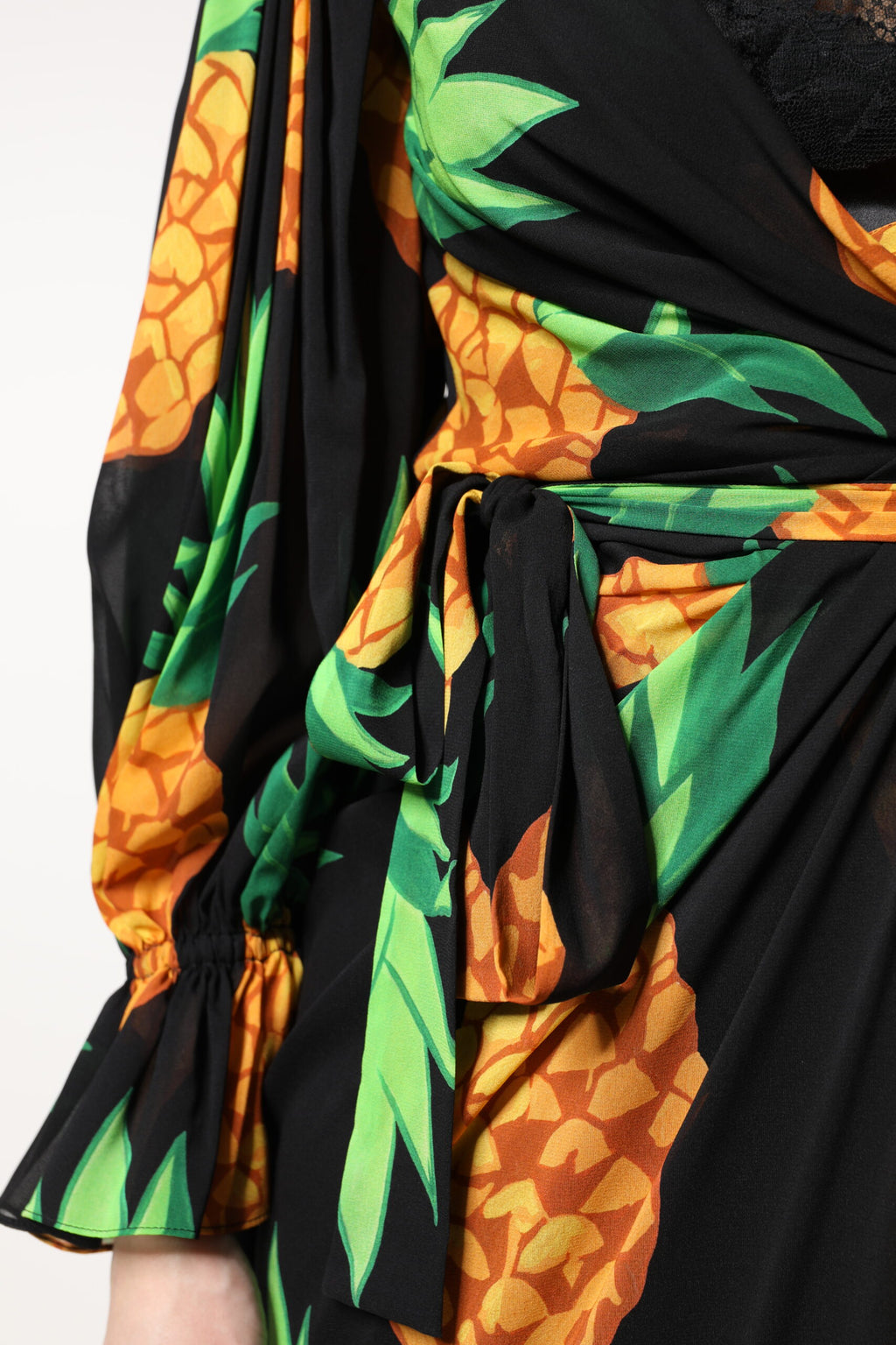 Robe portefeuille en soie noire Dolce & Gabbana avec motif ananas drapé, élégante et fluide.