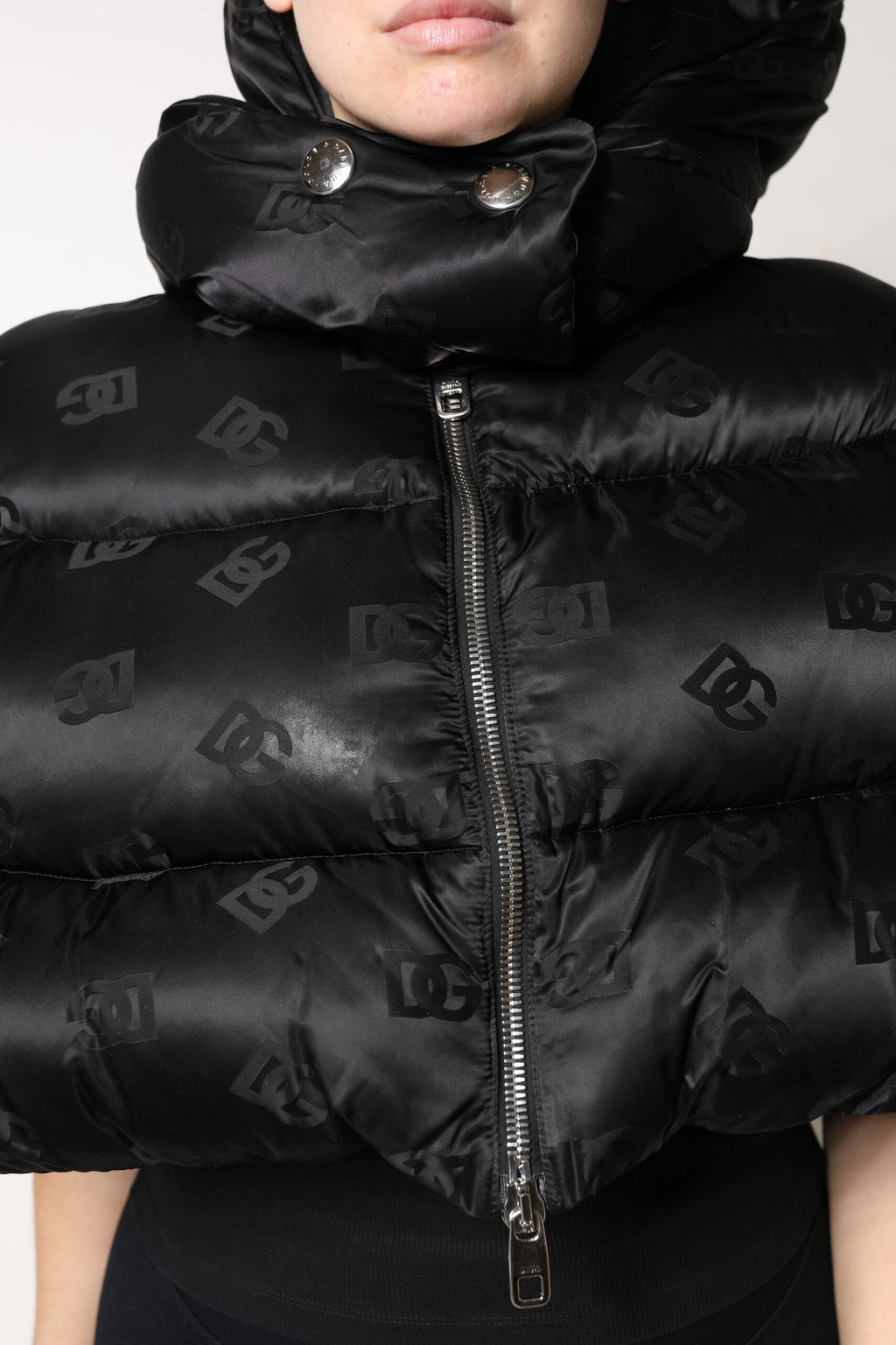 Veste courte noire matelassée Dolce & Gabbana avec capuche, fermeture éclair complète et design rembourré.
