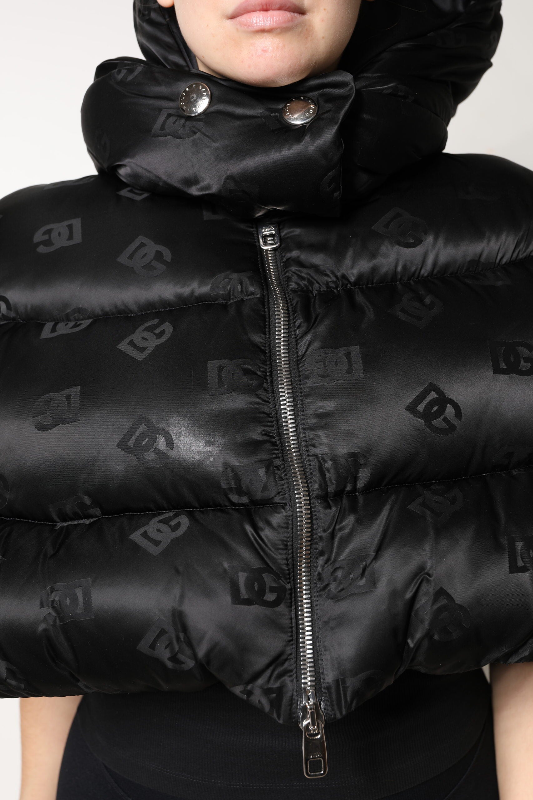 Veste courte noire matelassée Dolce & Gabbana avec capuche, fermeture éclair complète et design rembourré.