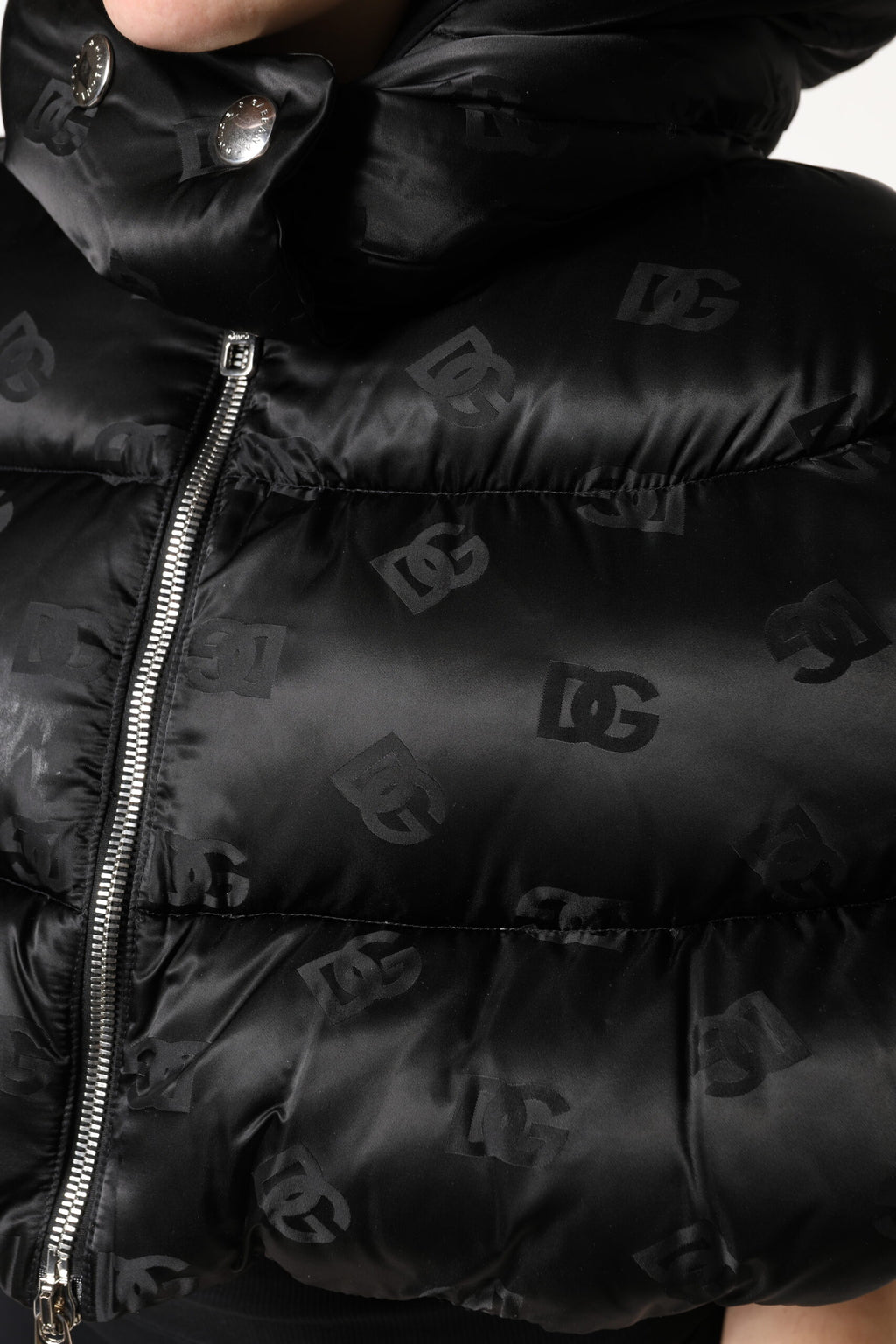 Veste courte matelassée noire Dolce & Gabbana avec capuche et fermeture éclair, style puffer chaud et tendance.