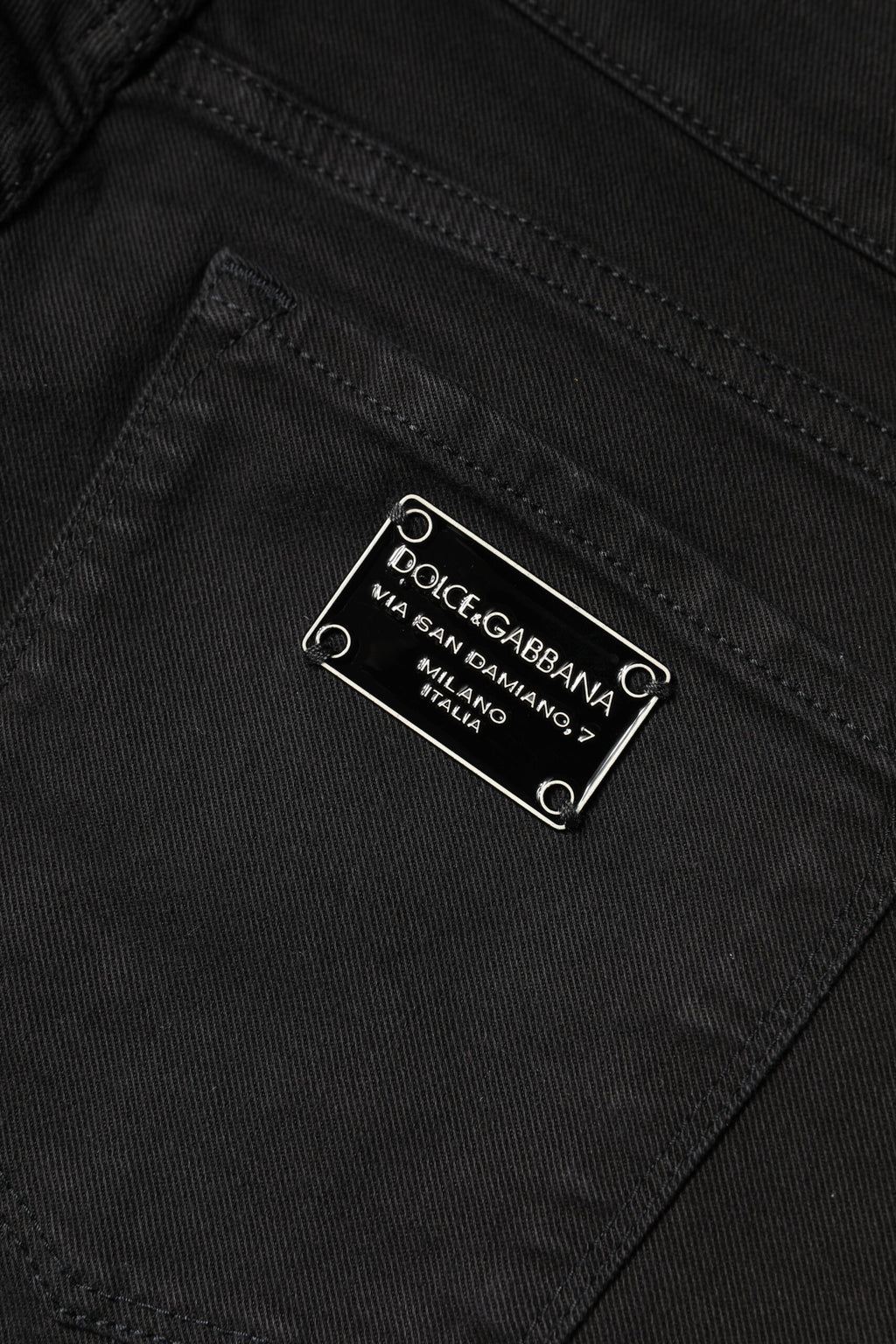 Jeans slim en coton noir Dolce & Gabbana, taille mi-haute, coupe skinny, visibles sur la photo.