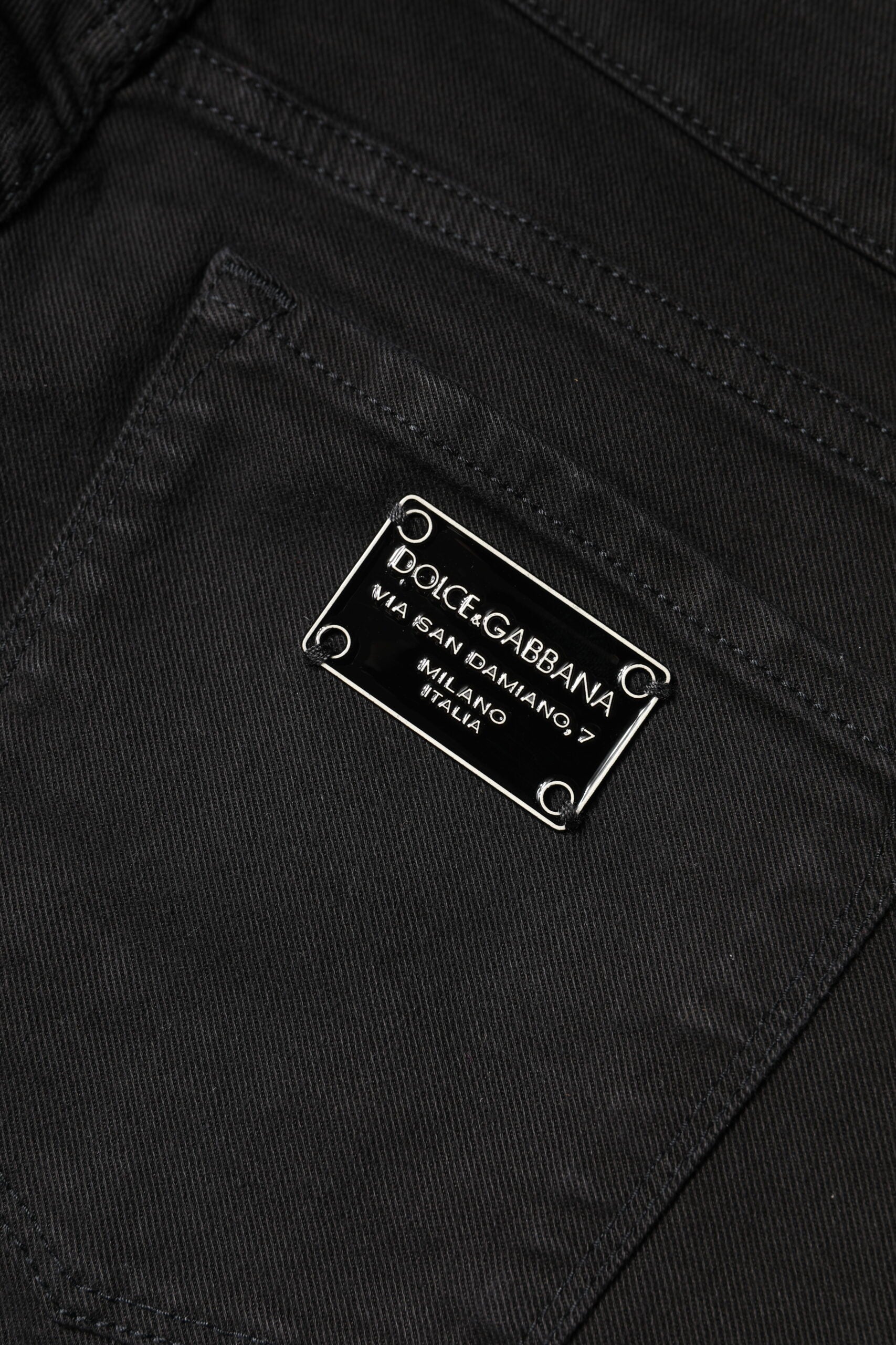 Jeans slim en coton noir Dolce & Gabbana, taille mi-haute, coupe skinny, visibles sur la photo.