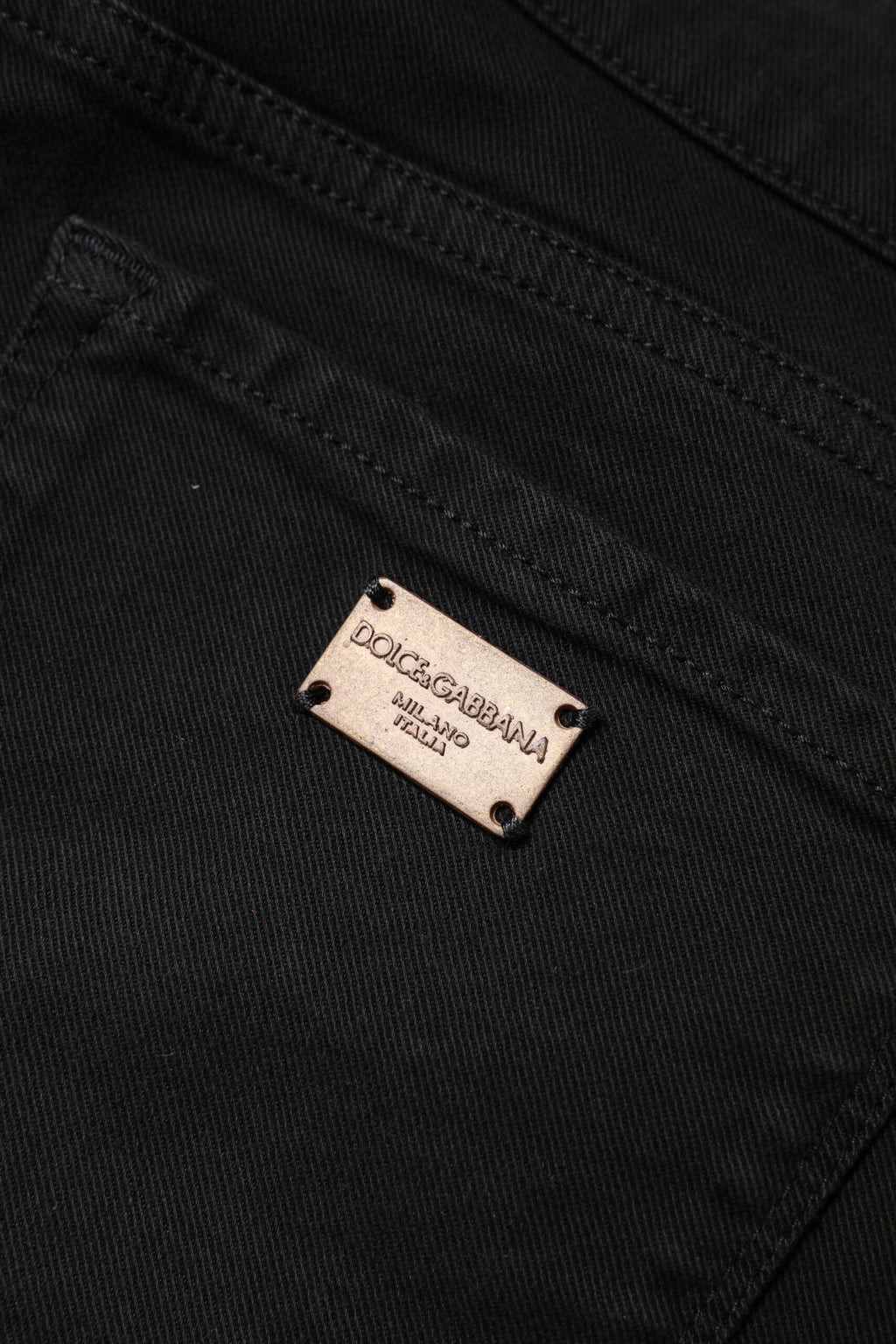 Jeans skinny en coton noir Dolce & Gabbana, taille mi-haute, coupe ajustée, visibles sur un mannequin.