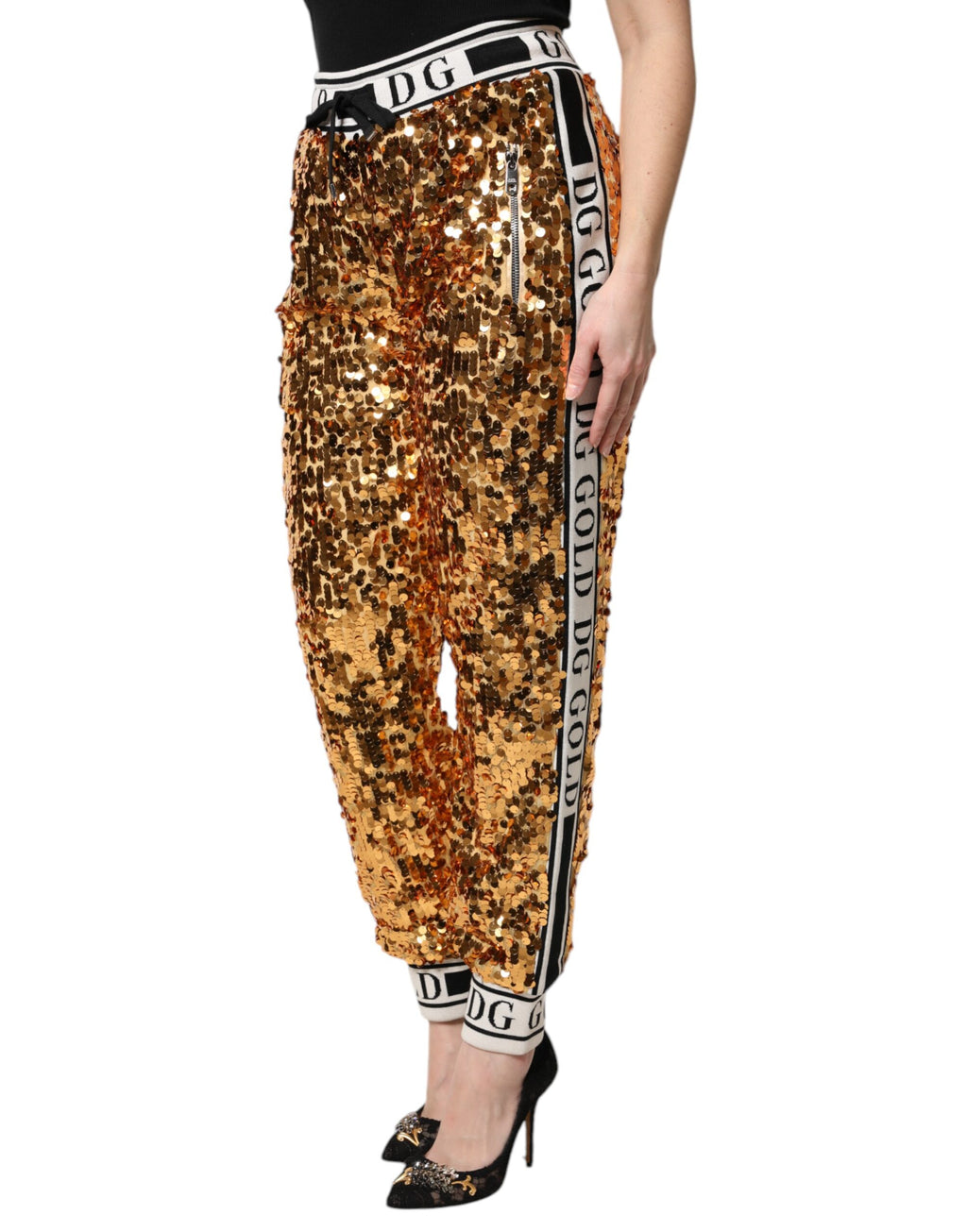 Pantalon jogging doré à sequins Dolce & Gabbana avec logo DG métallique, style élégant et tendance.