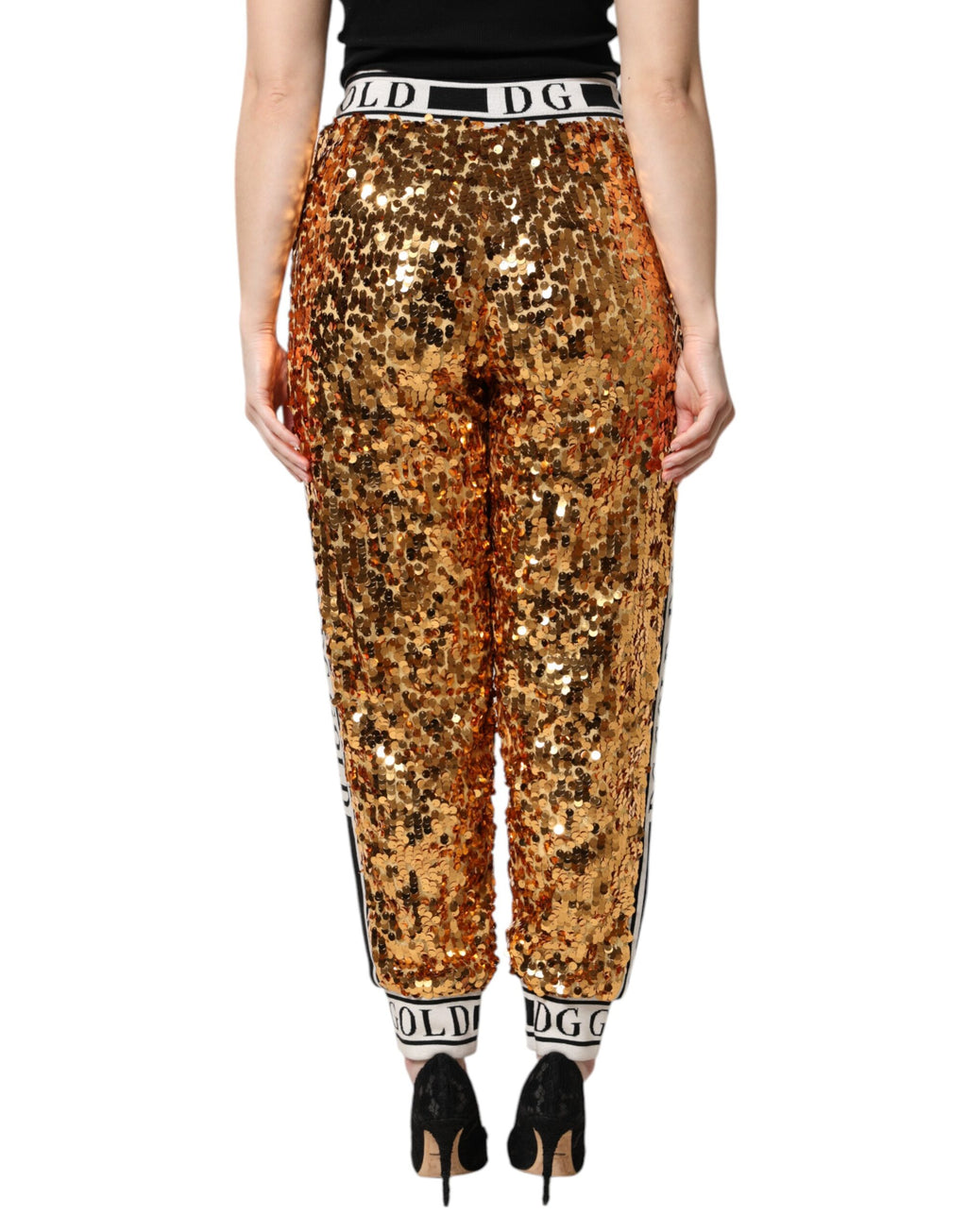 Pantalon jogger Dolce & Gabbana en sequins dorés métalliques avec logo DG, style élégant et brillant.