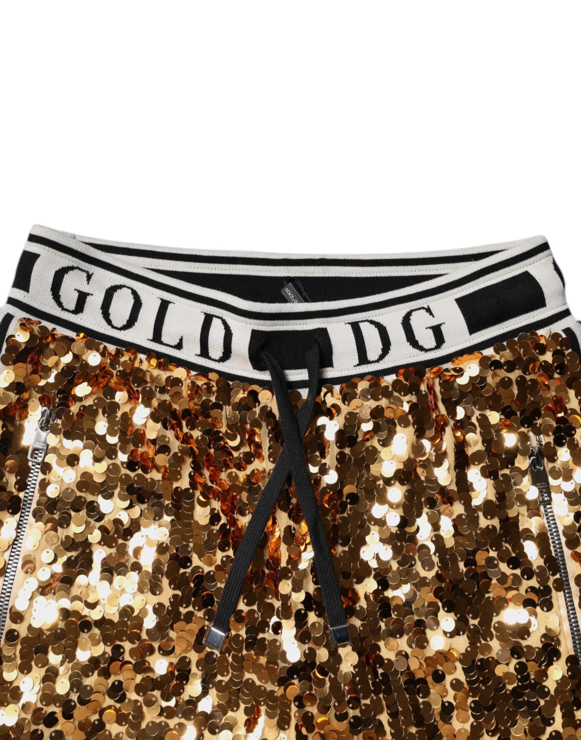 Pantalon jogger en sequins dorés métalliques avec logo Dolce & Gabbana en or, style décontracté et élégant.