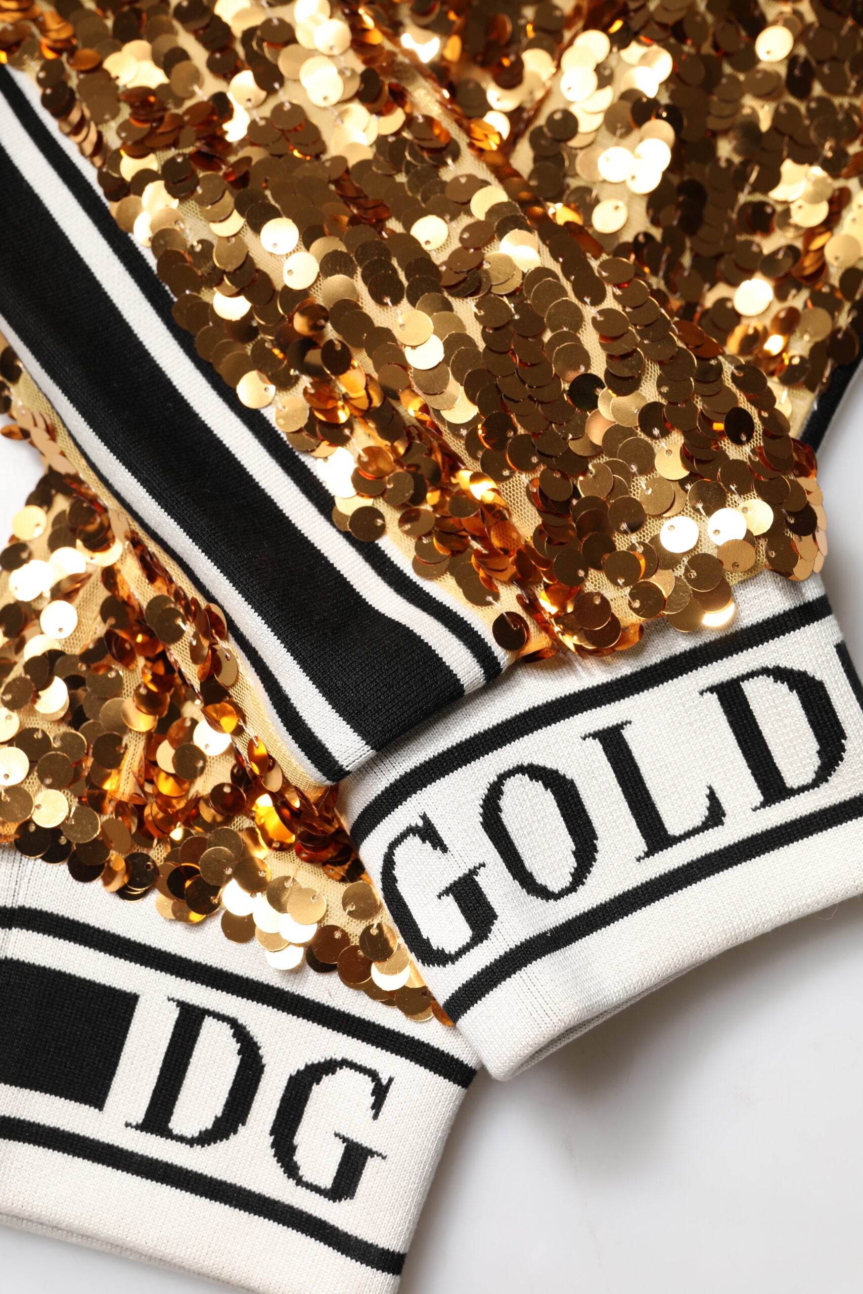 Pantalon jogger doré à sequins avec logo Dolce & Gabbana en métal, style élégant et brillant, pour femme.