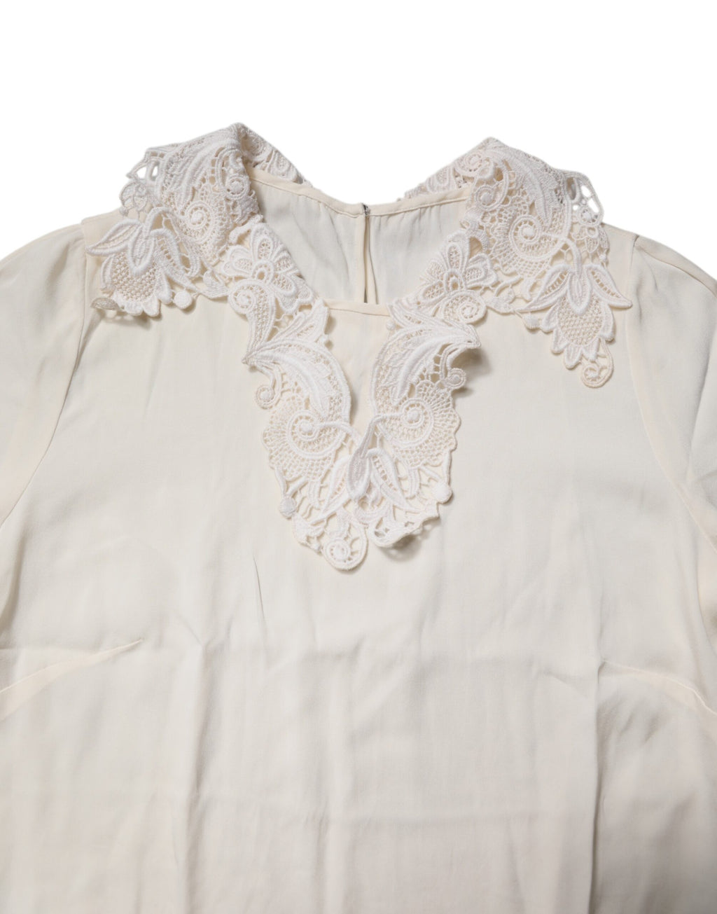 Blouse Dolce & Gabbana en dentelle crème à manches longues avec motifs floraux, élégante et raffinée.