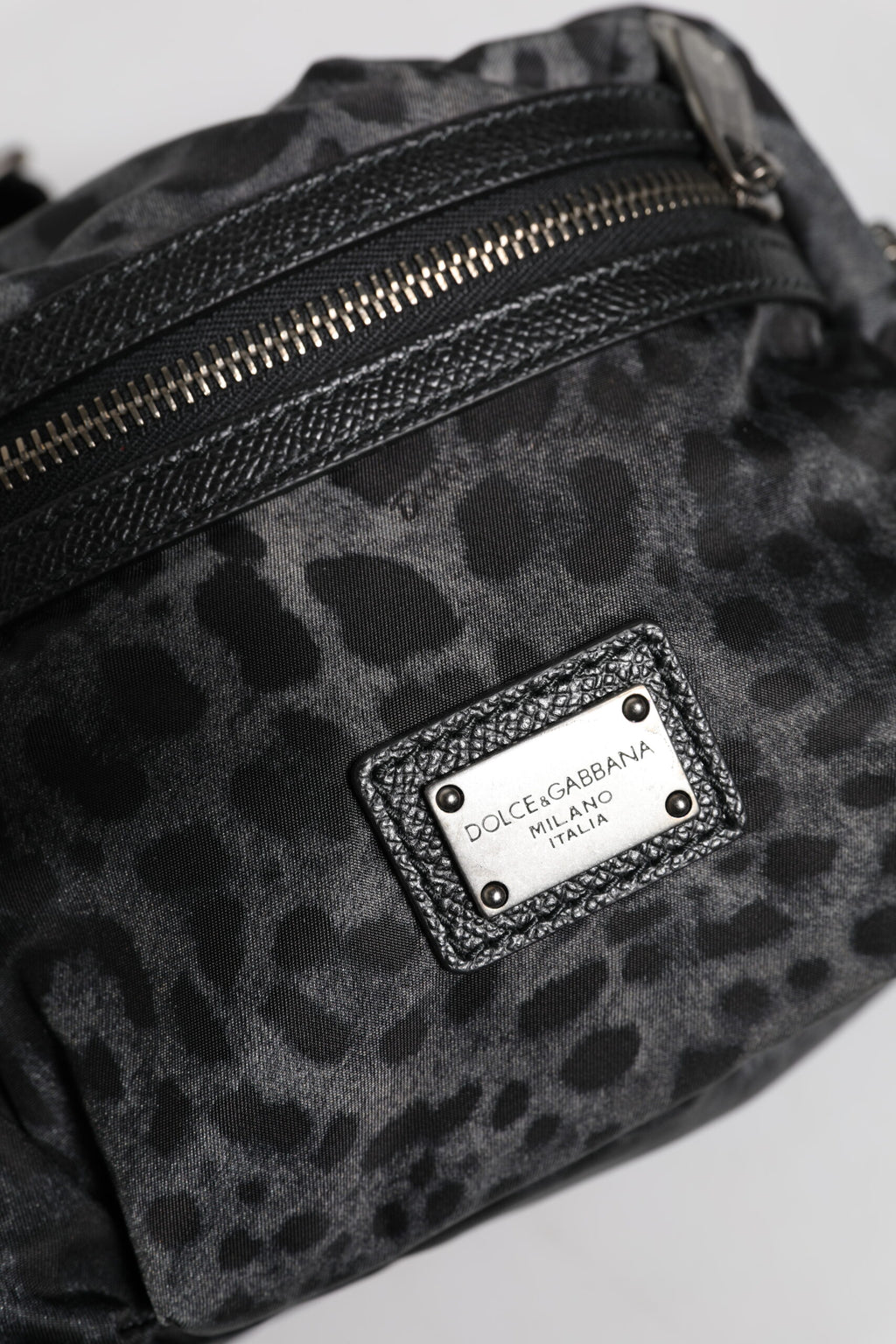 Ceinture fanny pack Dolce & Gabbana à motif léopard noir et gris avec logo DG, portée à la taille.