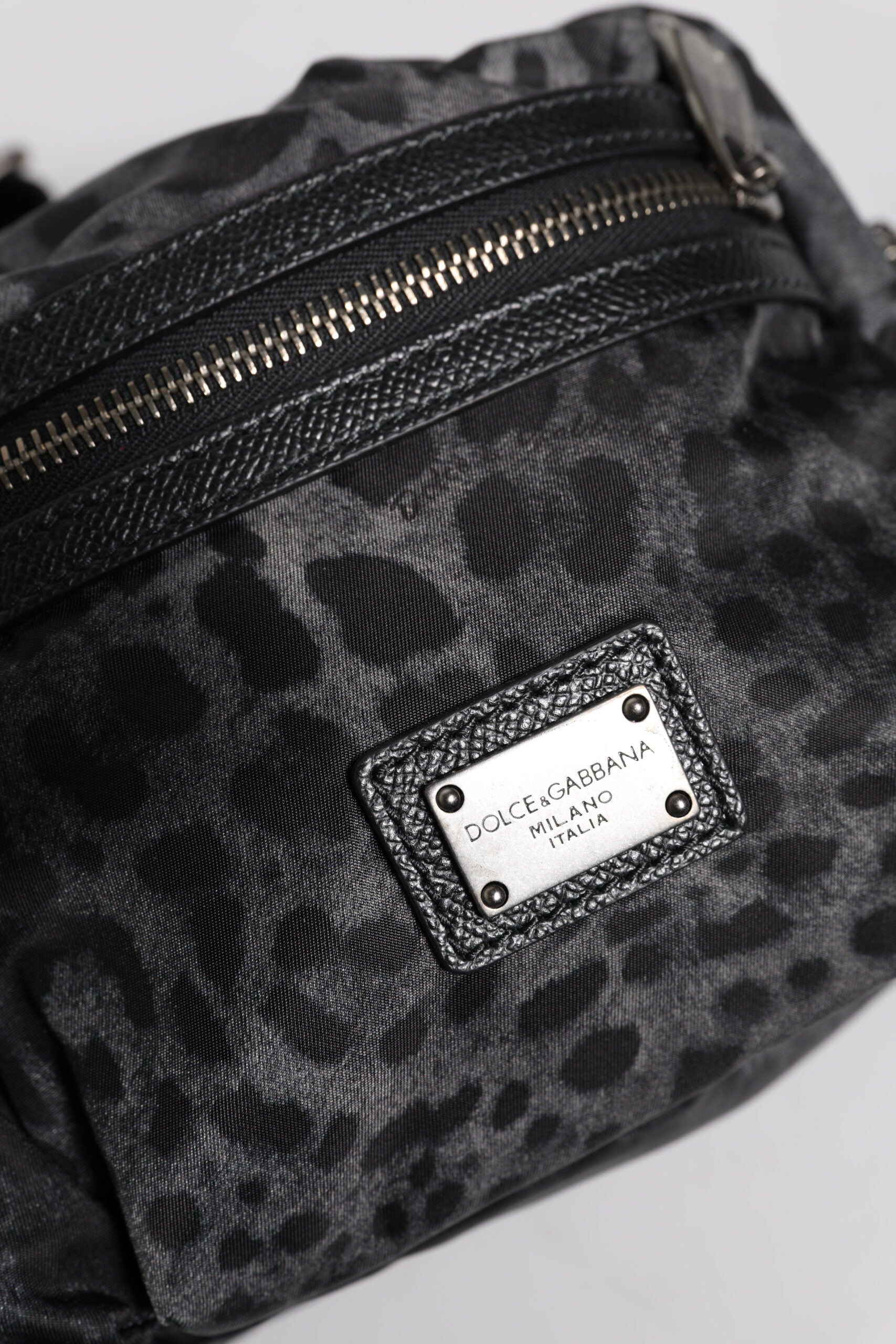 Ceinture fanny pack Dolce & Gabbana à motif léopard noir et gris avec logo DG, portée à la taille.