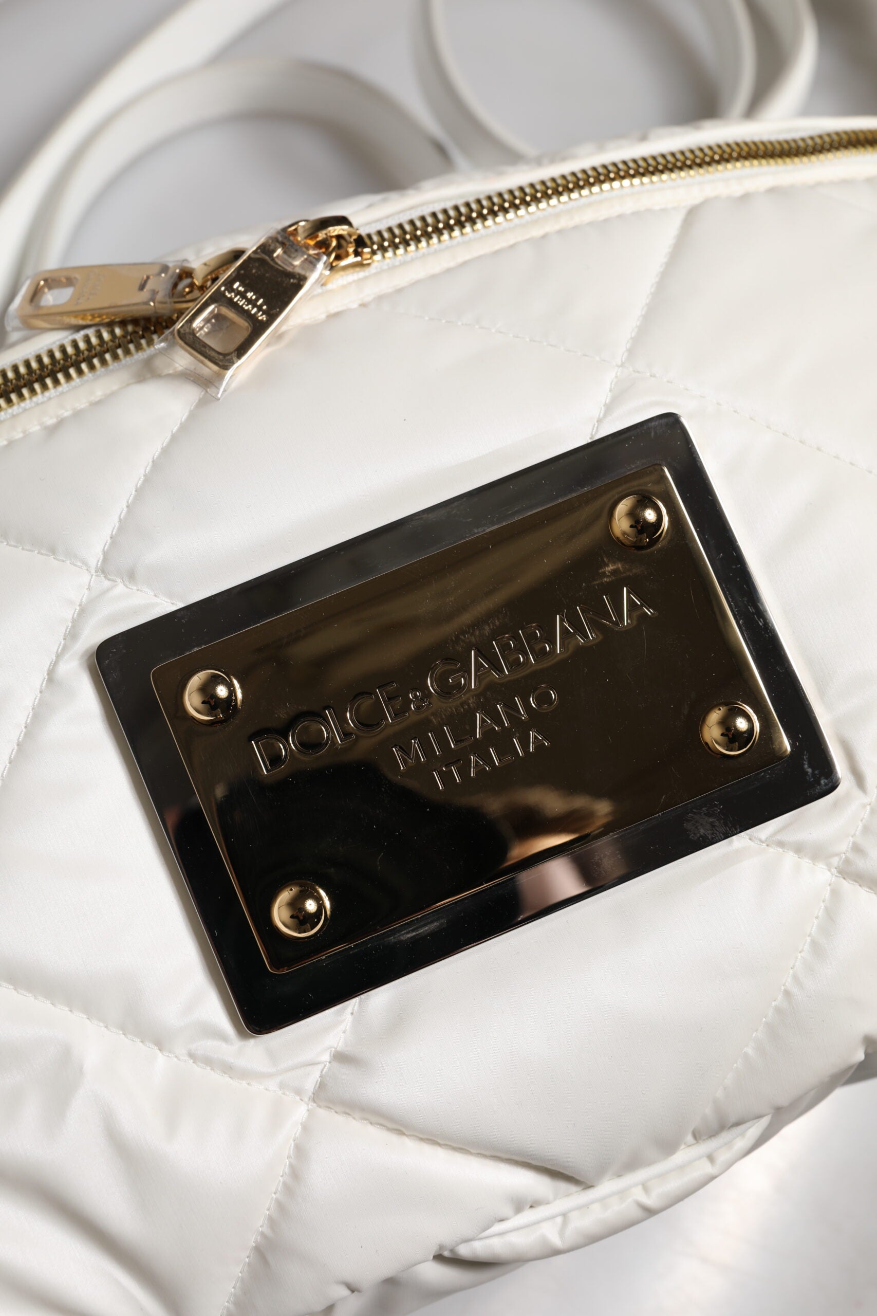 Sac banane Dolce & Gabbana blanc avec logo en relief, ceinture matelassée et plaque de marque élégante.