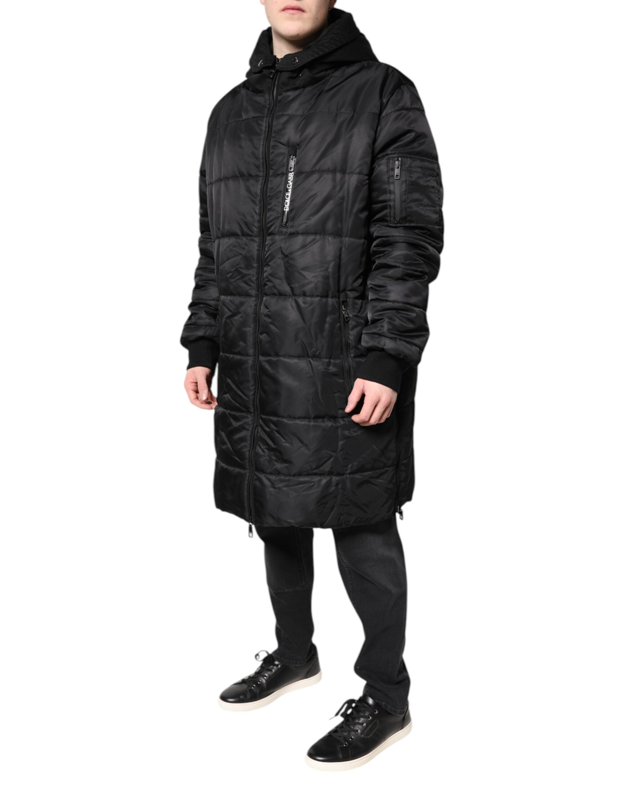 Manteau d'hiver noir avec capuche Dolce & Gabbana, parka chaud et élégant, porté en plein air avec fermeture à glissière.