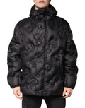 Veste d’hiver Dolce & Gabbana noire avec capuche, coupe longue, détails en tissu imperméable, style élégant et chaud.