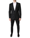Costume homme Dolce & Gabbana en laine noire à deux pièces, veste croisée simple boutonnage et pantalon assorti.
