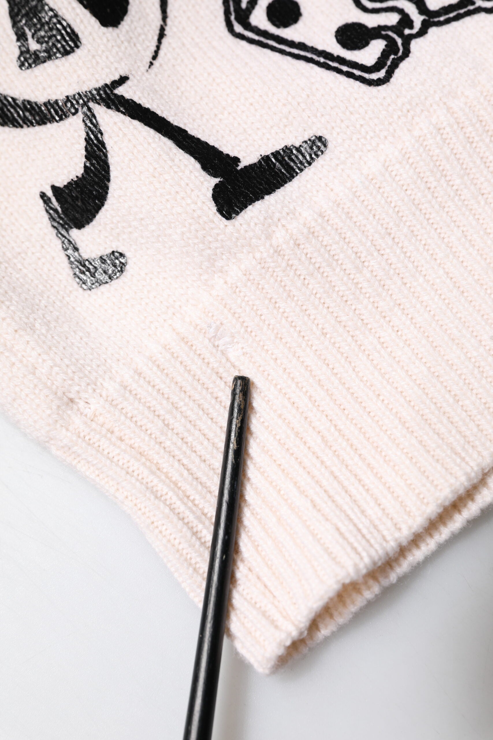 Pull à logo Dolce & Gabbana blanc et noir pour femmes, élégant, en laine, avec motif imprimé visible sur le devant.