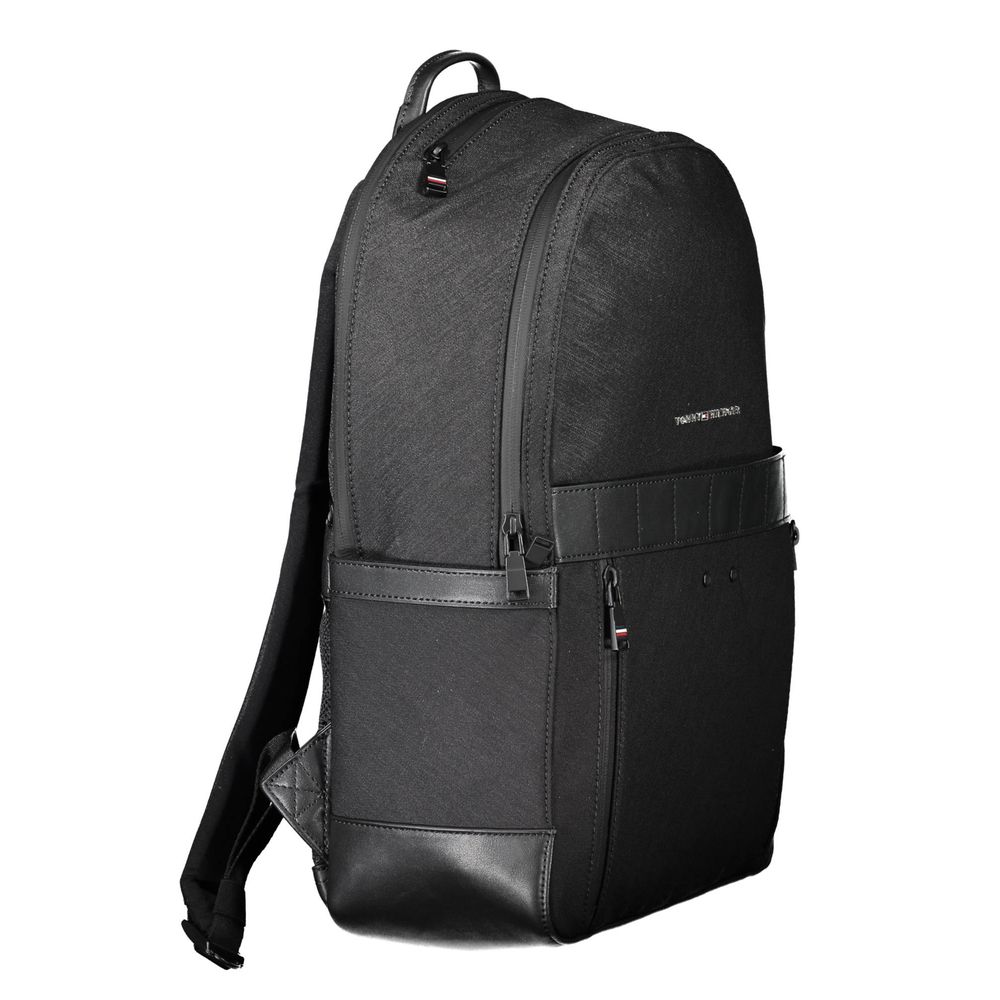 Sac à dos noir en nylon pour homme Tommy Hilfiger, avec poches zippées et logo visible sur le devant.