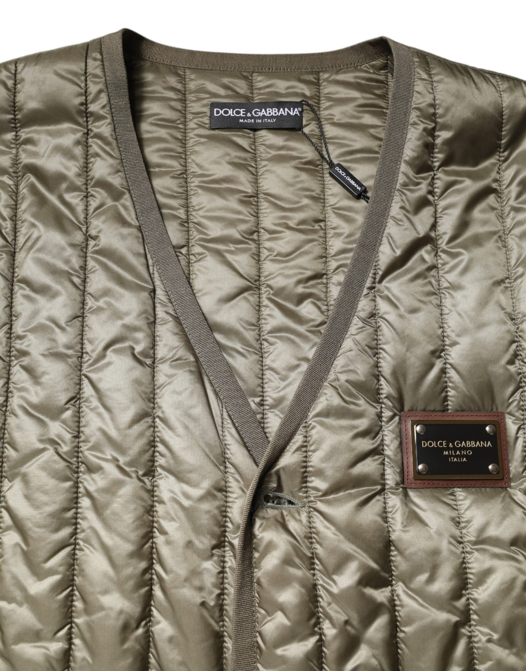 Gilet matelassé marron Dolce & Gabbana avec plaque logo, design élégant et tendance, détails visibles sur la veste.