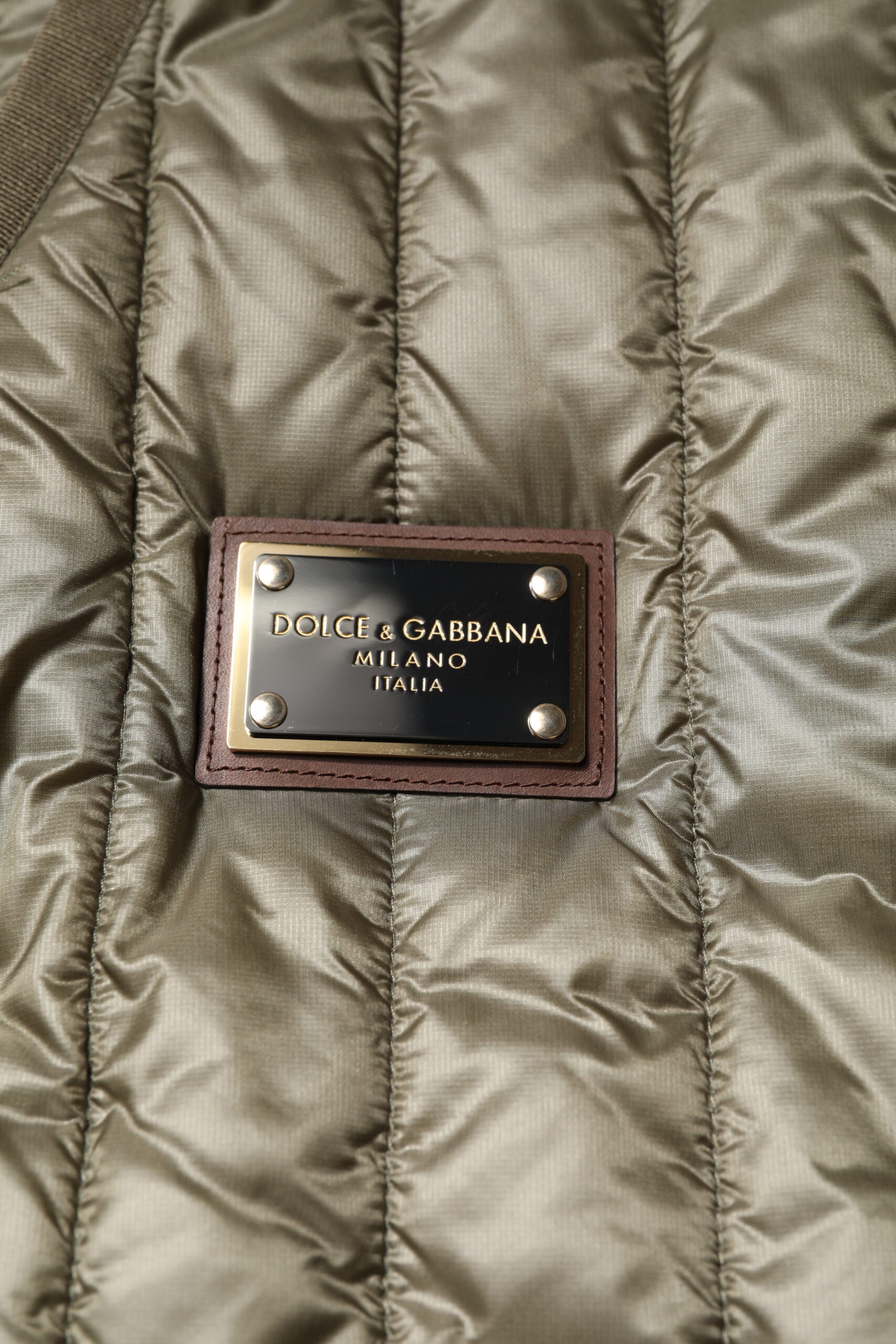 Veste matelassée marron Dolce & Gabbana avec plaque logo, design quilté et style élégant.
