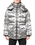 Veste matelassée zippée à capuche Dolce & Gabbana avec logo argenté visible, élégante et chaude, en tissu brillant argenté.