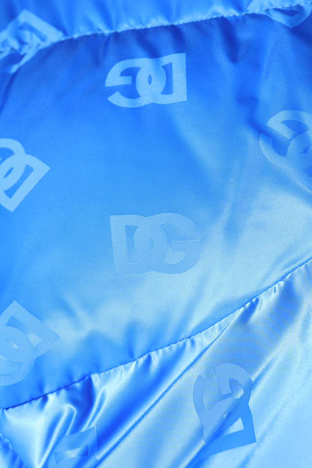 Veste matelassée à capuche Dolce & Gabbana, zip intégral, logo bleu sur le devant, design chaud et élégant.