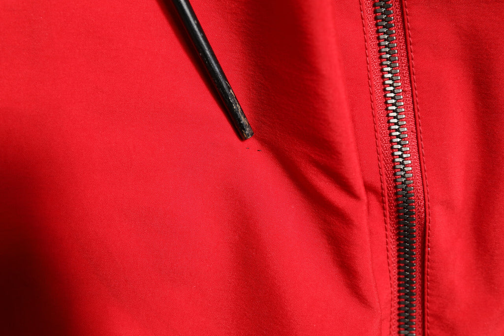 Veste coupe-vent en nylon rouge et blanc de Dolce & Gabbana, avec fermeture éclair intégrale, style moderne et élégant.