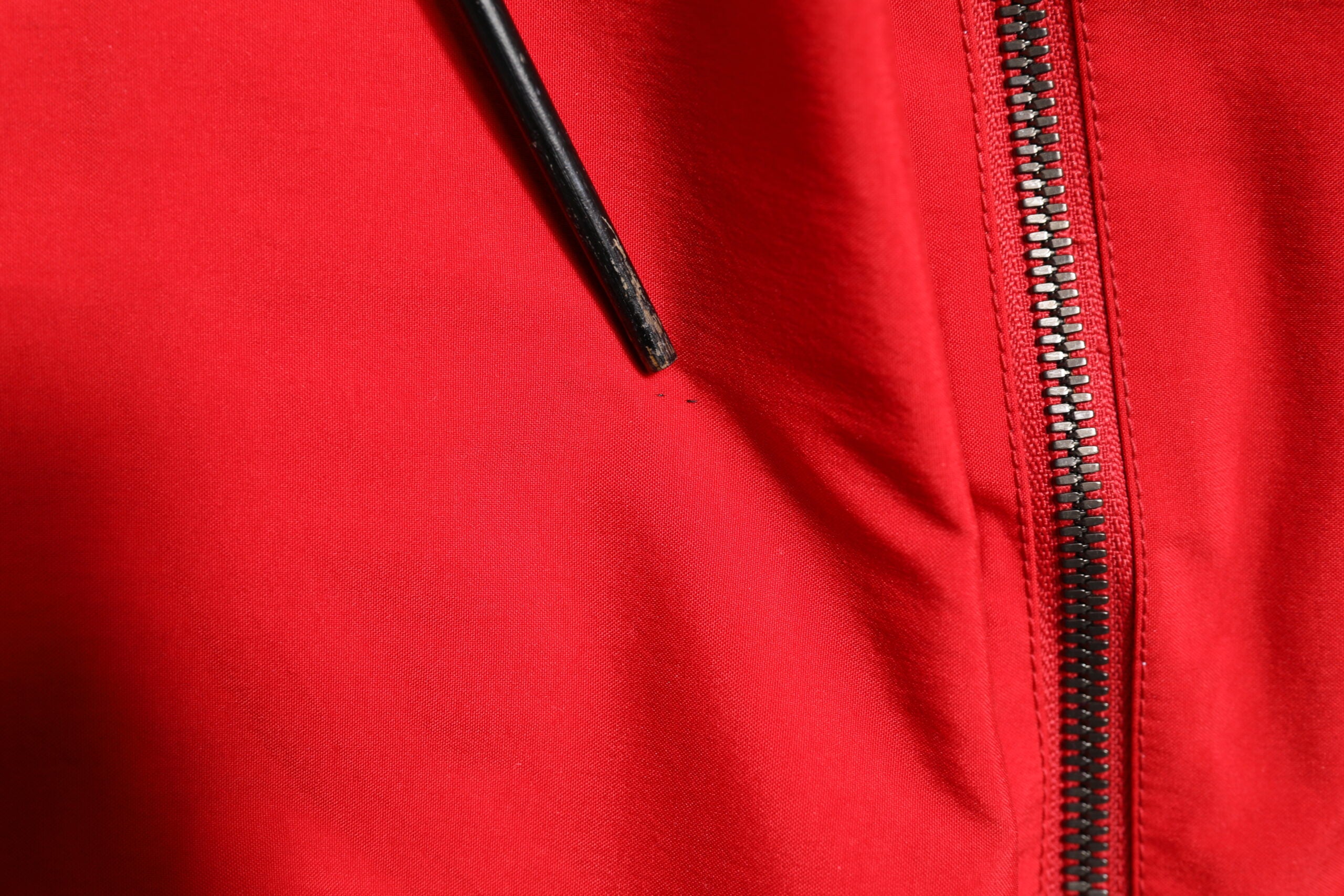 Veste coupe-vent en nylon rouge et blanc de Dolce & Gabbana, avec fermeture éclair intégrale, style moderne et élégant.