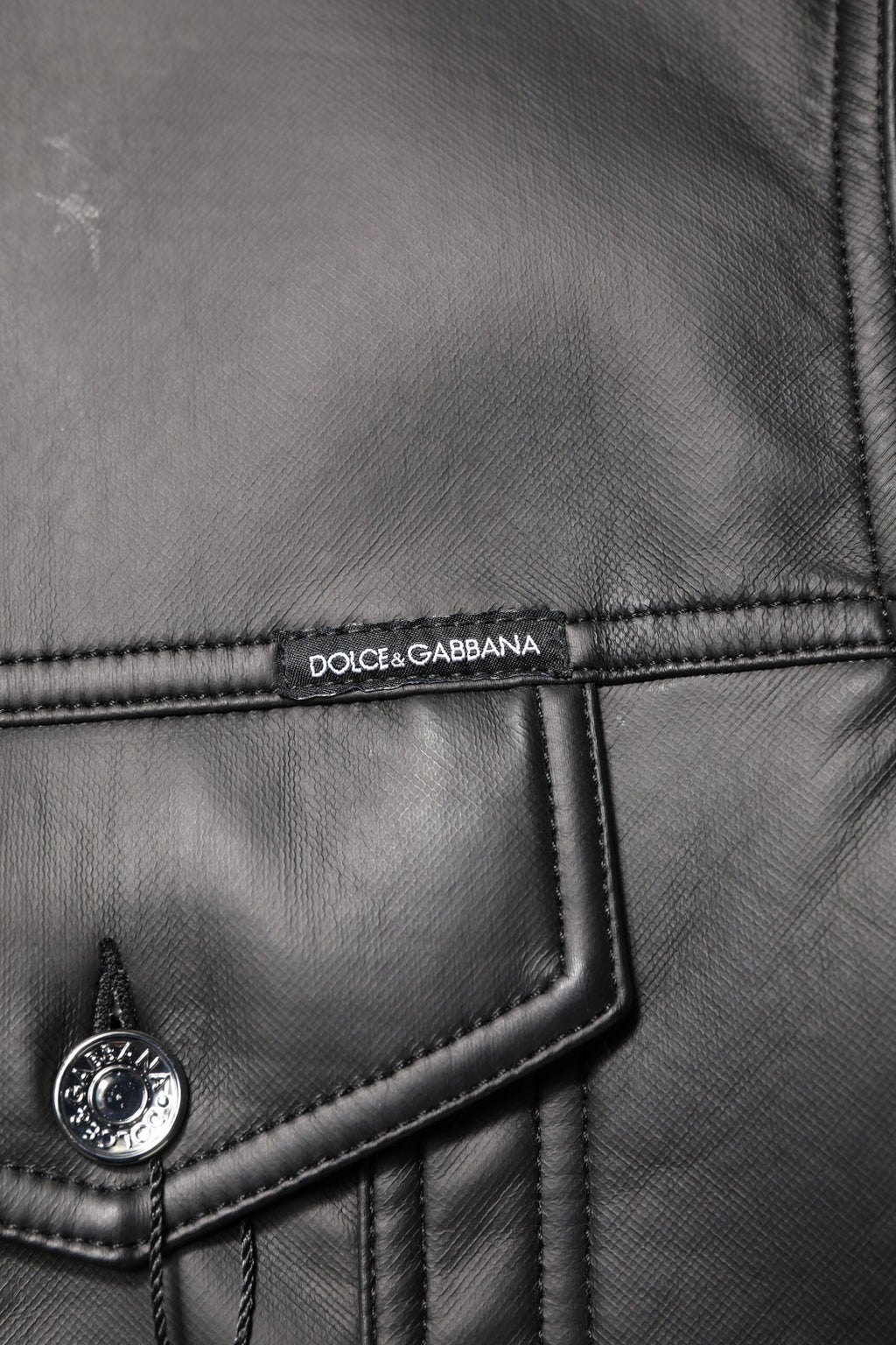 Veste biker noire en polyester Dolce & Gabbana avec boutons, style élégant et moderne, vue de face.