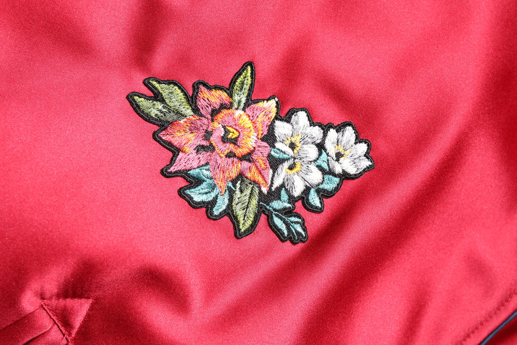 Veste bomber homme Dolce & Gabbana rouge à patchs floraux, fermeture éclair complète, style élégant et tendance.