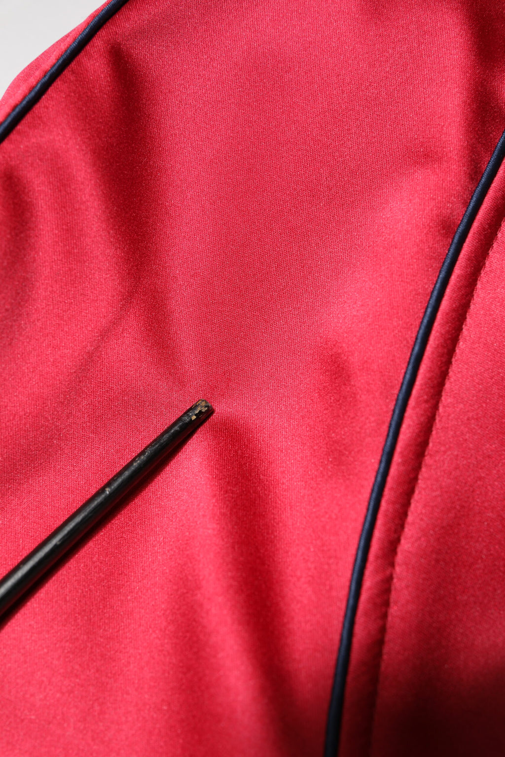 Veste bomber homme Dolce & Gabbana rouge avec patch floral, zip complet, style tendance et détails colorés.