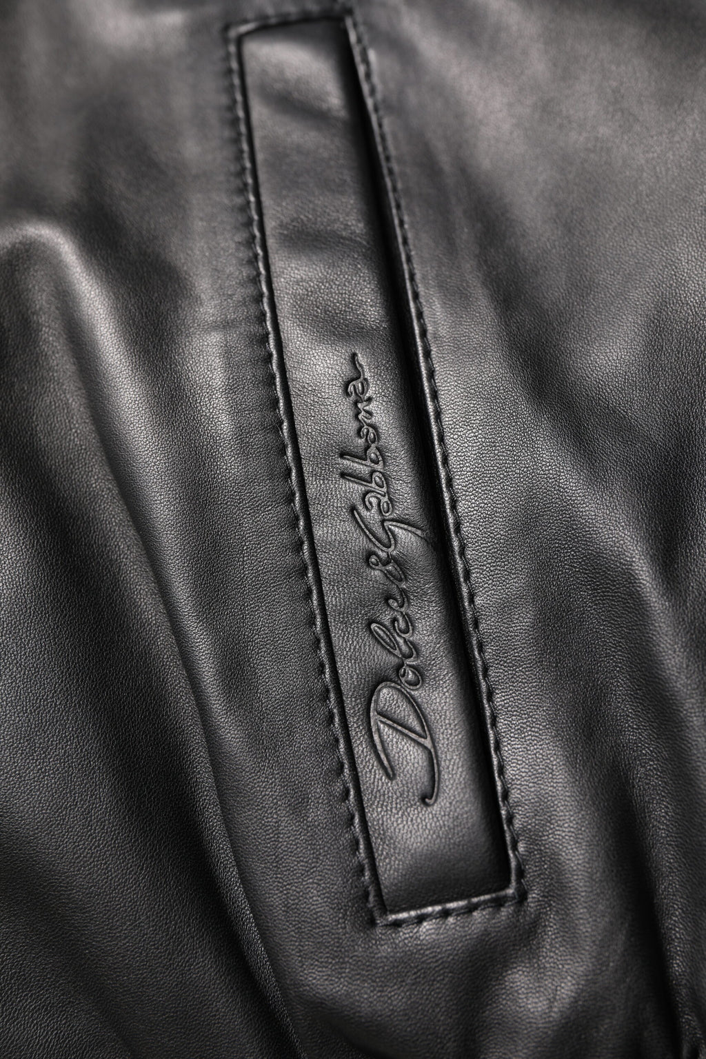 Veste en cuir de mouton noir Dolce & Gabbana à zip intégral, style biker, visible avec détails en cuir lisse et coupe ajustée.