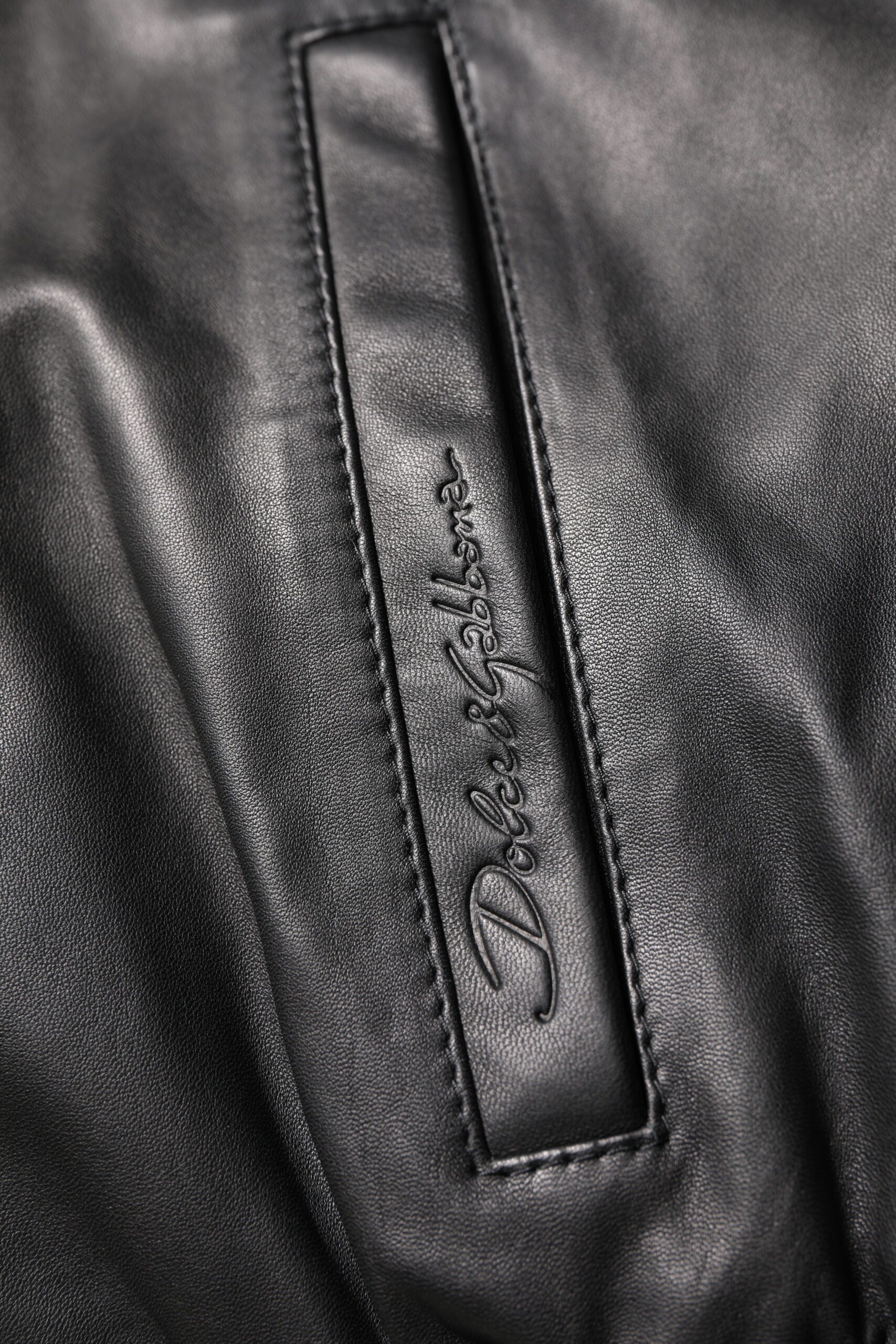 Veste en cuir de mouton noir Dolce & Gabbana à zip intégral, style biker, visible avec détails en cuir lisse et coupe ajustée.