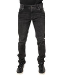 Jeans skinny en denim gris délavé de Dolce & Gabbana, coton léger, visible sur le modèle, avec détails de couture.