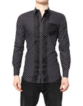 Chemise formelle noire à pois blancs et manches longues Dolce & Gabbana avec détails dorés, vue de face.