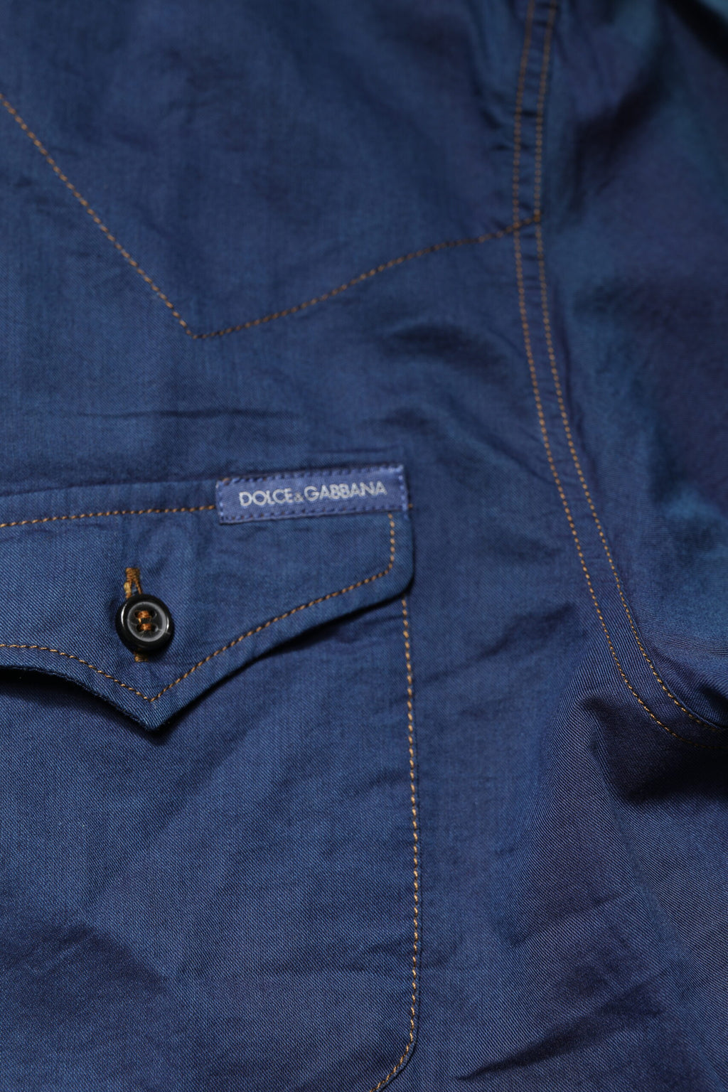 Chemise décontractée à manches longues en coton bleu Dolce & Gabbana avec détails dorés, style casual élégant.