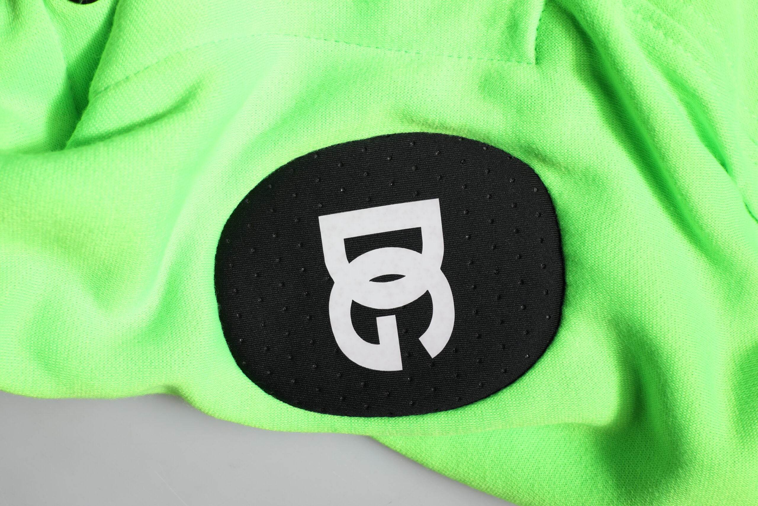 Veste sportive en polyester vert Dolce & Gabbana avec capuche et design décontracté, portée sur un mannequin.